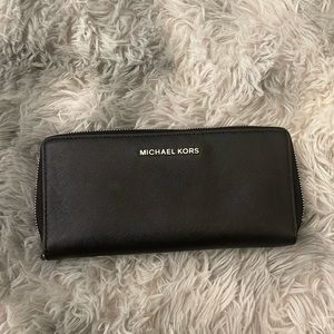 Black Michael Kors wallet with zipper and many compartment’s
